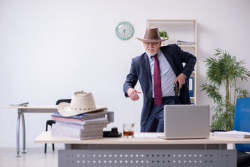 Funny old boss in cowboy hat in the office