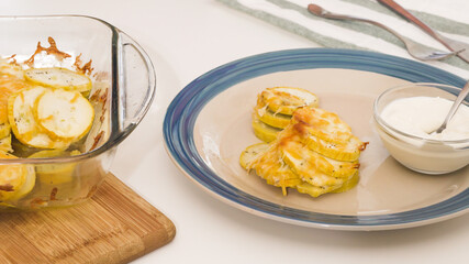 Baked zucchini recipe. Zucchini slices with seasoning salt, black pepper and cheese, served with sour cream.