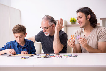 Three generations of family playing jigsaw puzzle game