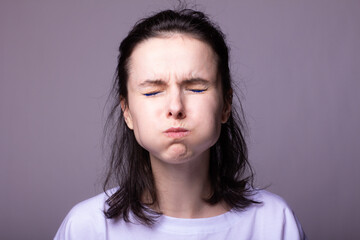 emotional woman in white t-shirt on gray studio background