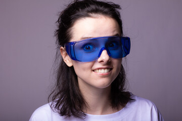 funny girl in big blue glasses, gray background