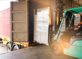 Workers Driving Forklift Tractor Loading Cargo Pallets into Container Trucks. Shipping Warehouse. Delivery Service Shipment Boxes. Supply Chain Goods. Warehouse Cargo Logistics Transport. © Siwakorn1933