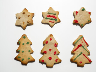 Homemade Christmas gingerbread cookies isolated on white background. Pine and star shaped cookies. Decorated Christmas cookies