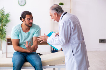 Injured young man visiting old doctor