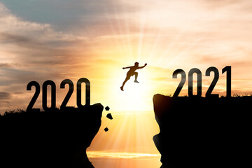 Welcome merry Christmas and happy new year in 2021,Silhouette Man jumping from 2020 cliff to 2021...