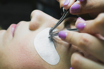 Eyelash Extension Procedure. Woman Eye with Long Eyelashes. Lashes, close up, selective focus.