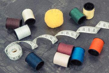 Spools of thread, needle, tape measure and scissors. Accessories for needlework