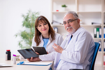 Fototapeta premium Old male doctor radiologist and his young female assistant in th
