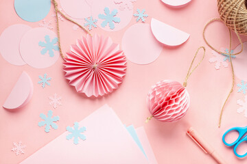 Christmas handmade background. Female hands making paper decoration balls.  DIY accessories on white table. Top view. Zero waste concept.