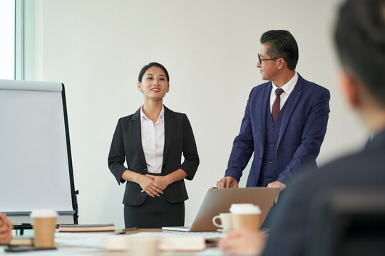 young asian new employee introduced to team by boss during staff meeting in office