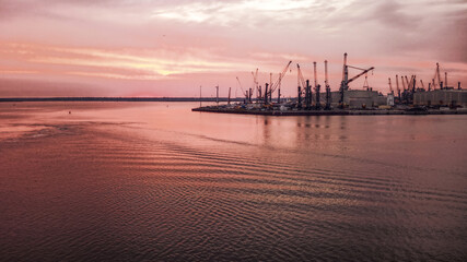 Fototapeta na wymiar Industrial port in Rostock with cranes in dawn
