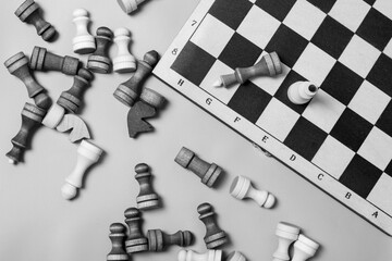 The end of the chess game, the victory of white, the black chess king is defeated, chess pieces lie...