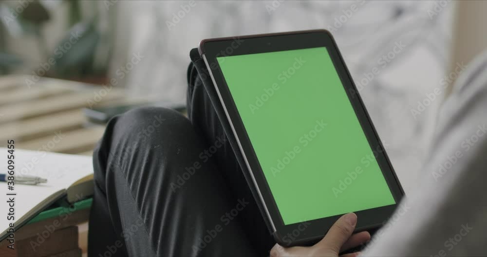 Wall mural Woman holding tablet computer with green screen