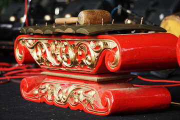 Naklejka premium Red Javanese Gamelan. Traditional musical instruments from Indonesia. The frame was wood painted red, the blade was made of bronze