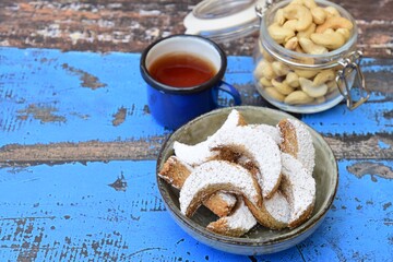 Putri Salju Kacang Mede or crescent-shaped cookies with cashew coated with powdered sugar. Popular Indonesian dessert to celebrate Eid al Fitr or Idul Fitri