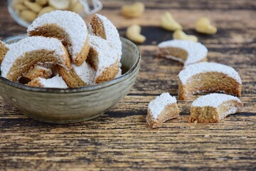 Putri Salju Kacang Mede or crescent-shaped cookies with cashew coated with powdered sugar. Popular Indonesian dessert to celebrate Eid al Fitr or Idul Fitri