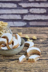 Putri Salju Kacang Mede or crescent-shaped cookies with cashew coated with powdered sugar. Popular Indonesian dessert to celebrate Eid al Fitr or Idul Fitri