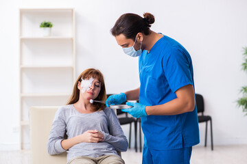 Obraz premium Young head injured woman visiting young male doctor