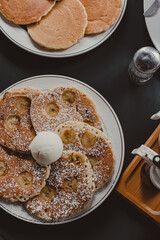Banana pancakes with ice cream on a black table – cafe breakfast in Japan.