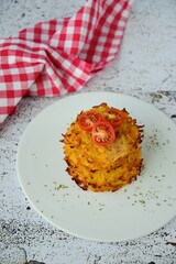Hash browns or potato pancakes or Swiss Rösti garnish with cherry tomato and parsley