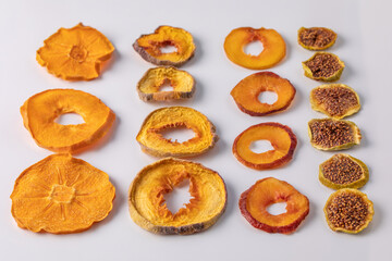 slices of dried persimmon, peach, plum and figs on a white background. dried fruits. eco.