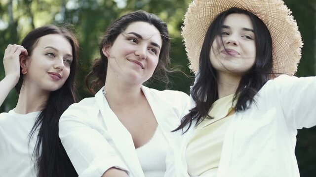 Friends party concept. Photo of happy European women taking selfie photo and laughing. The adies are having fun together outdoors.