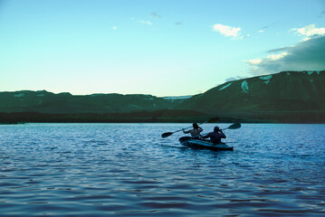 A man and a woman are canoeing on a mountain lake. Beautiful landscape of a mountain lake in Norilsk, Taimyr
