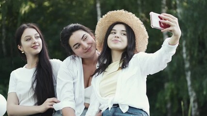 Friends party concept. Photo of happy European women taking selfie photo and laughing. The adies are having fun together outdoors.