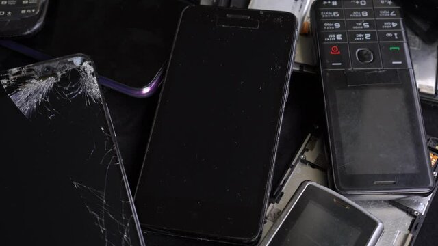 Electronic waste: Used old mobile phone, obsolete and broken smartphones, digital tablets, smart watches, with cracked screen. Reuse and Recycling