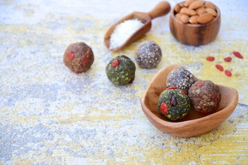 Homemade healthy raw vegan assorted energy balls with seeds, almond nuts, walnuts, goji berry, spirulina, coconut, cacao powder, acai berry and dates
