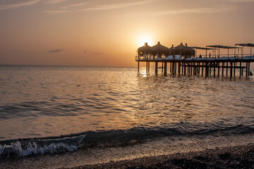 Fototapeta na wymiar Beautiful sunset over the sea and pier