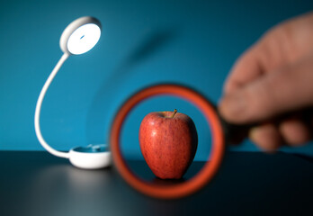 Looking at an apple through a magnifying glass health concept