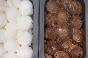 Scoop chocolate ice cream and coconut milk ice cream in box