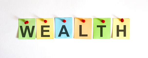 WEALTH phrase is written on multi-colored stickers, on the white background. Business concept,...