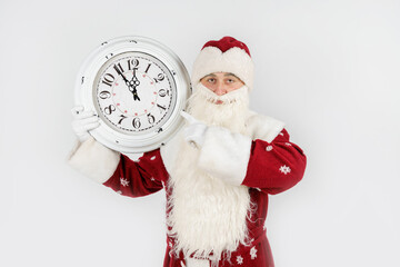 Santa Claus shows the time remaining before Christmas on the clock. Isolated on white