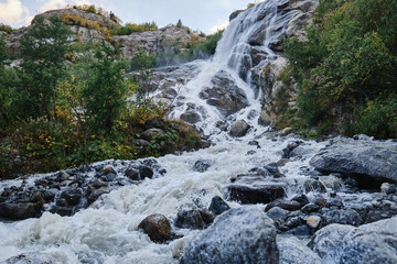 Fototapeta na wymiar Mountain river. Waterfall view. Wild river stream rocks flowing. River rocks view.