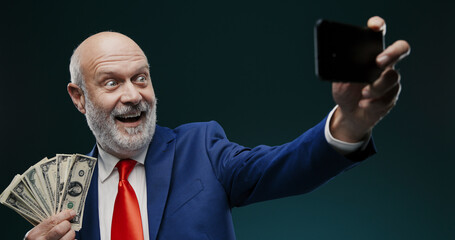 Businessman taking a selfie while holding cash money