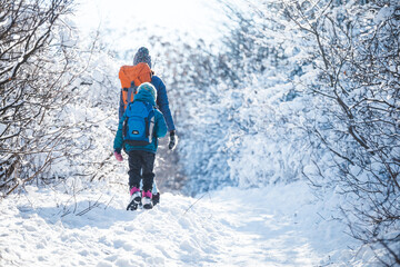 Woman with a child on a winter hike in the mountains.