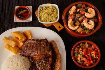 typical Brazilian barbecue, dish with picanha, rice, farofa, feijão tropeiro, beens, cassava
