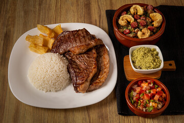 typical Brazilian barbecue, dish with picanha, rice, farofa, feijão tropeiro, beens, cassava
