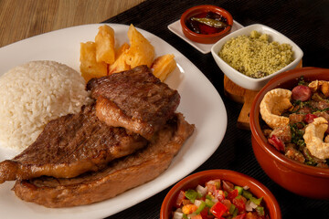 typical Brazilian barbecue, dish with picanha, rice, farofa, feijão tropeiro, beens, cassava
