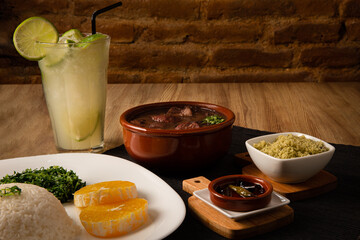 traditional Brazilian dish called feijoada, contains rice, beens, beef, pork, orange, vegetables
