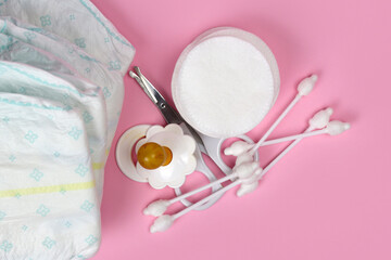 diapers and baby hygiene products on a pink background