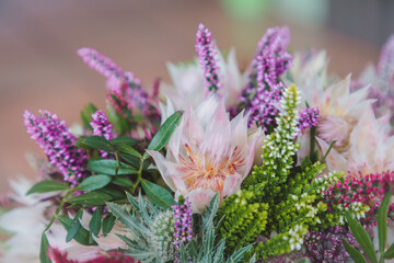 Beautiful autumn, wedding bouquet made out of a sortiment of sessional flowers, such as Calluna Vulgaris, Astrantia, Eryngium and white blushing bride Protea