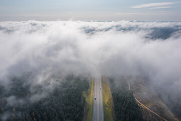 Beautiful hight way road high angle beautiful view of the fog over the road on an early summer morning in central Russia. Aerial view of the road and skyline.