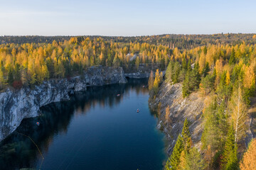 Fototapeta na wymiar Autumn view from a drone to a quarry in the Ruskeala mountain park. A tourist place in Karelia. Typical nature of the Russian north.