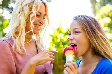 Mom with her kid baby eating ice cream in park and smiling in tropical beach