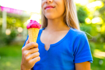 Pretty little girl eating an ice cream outdoors