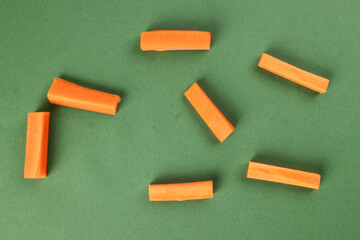 chopped sliced diced carrot on green background
