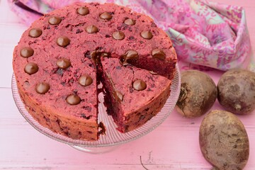 Beetroot chocolate cake with chocolate chips on pink background. 